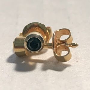 Gold toned piercing earrings with green gemstone.